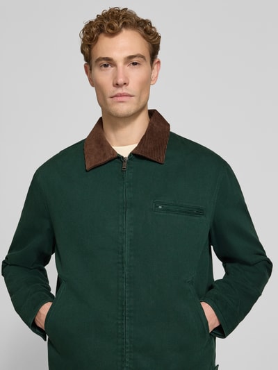 Männermodel trägt Regular Fit Jacke aus reiner Baumwolle von MCNEAL, grün mit braunem Cordkragen, Nahaufnahme Oberkörper.