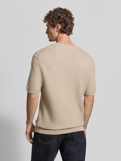 Männermodel trägt Regular Fit Strickshirt aus reiner Baumwolle Modell 'H-NILTON' von BOSS, Optik: Unifarben, Struktur-Muster, Rundhals, Kurzarm, Rumpfabschluss: Gerippt, Materialverarbeitung: Strick, Farbe Beige, Ganzkörperansicht Rückansicht.