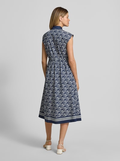 Frauenmodel trägt Hemdblusenkleid in Midi-Länge aus Baumwolle-Seide-Mix von Tommy Hilfiger mit Allover-Muster, tailliert, Rückansicht.
