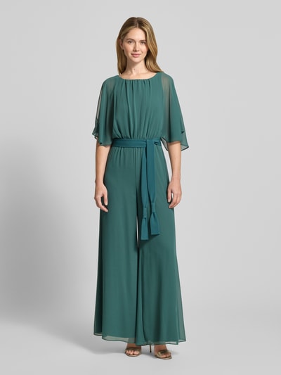 Frauenmodel trägt Jumpsuit aus fließendem Stoff mit Bindegürtel von Vera Mont in grünem Chiffon, weite Beine, Ganzkörperansicht von vorne, Rückenlänge Größe 36: 146 cm, Brustweite: 33 cm, Ärmellänge: 30 cm, Gesamtlänge: 147 cm, Innenbeinlänge: 81 cm.