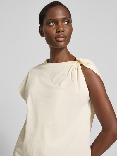 Frauenmodel trägt T-Shirt im One-Shoulder-Look Modell 'ALLIA' von Bash in Creme, reine Baumwolle, Regular Fit, Nahaufnahme Oberkörper.