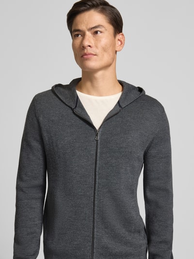 Männermodel trägt Regular Fit Strickjacke mit Lanawoll-Anteil von Christian Berg Men in Dunkelgrau, sichtbarer Zipper, Nahaufnahme Oberkörper, Material-Mix Kontext.