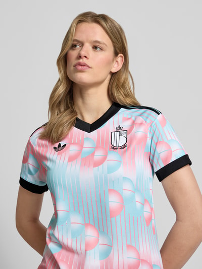Frauenmodel trägt T-Shirt Trikot mit Logo-Applikation von adidas Sportswear, Mehrfarbig, Regular-Fit, V-Ausschnitt, Kurzarm, Nahaufnahme Oberkörper.