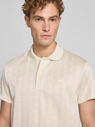 Männermodel trägt Classic Fit Poloshirt mit Logo-Detail von Lacoste in Beige mit feiner Musterstruktur, Nahaufnahme Oberkörper. Herren Poloshirt von Lacoste