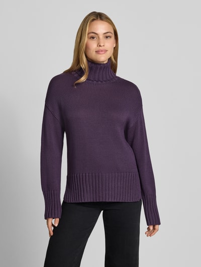 Frauenmodel trägt Relaxed Fit Strickpullover aus reiner Baumwolle mit Rollkragen von MOS MOSH in Lila, Damenmodell, gerade Formen, elastische Abschlüsse, Rückenlänge und Ärmellänge je 62 cm, Ganzkörperansicht von vorne.