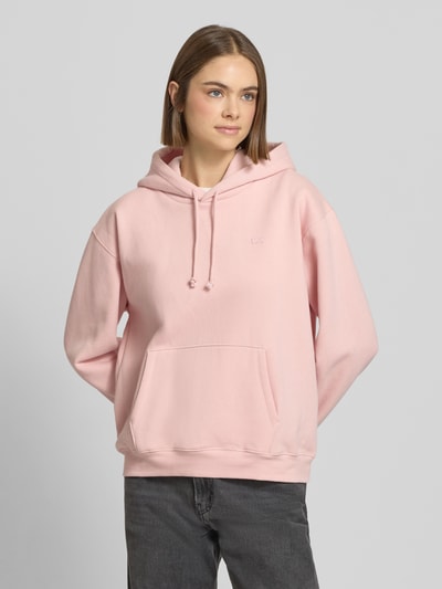 Vrouwenmodel draagt Hoodie met Kapuze van Levi's®, lichtroze katoenmix, losse pasvorm, buidelzak, ribboorden, frontaal zicht, bovenlichaam.
