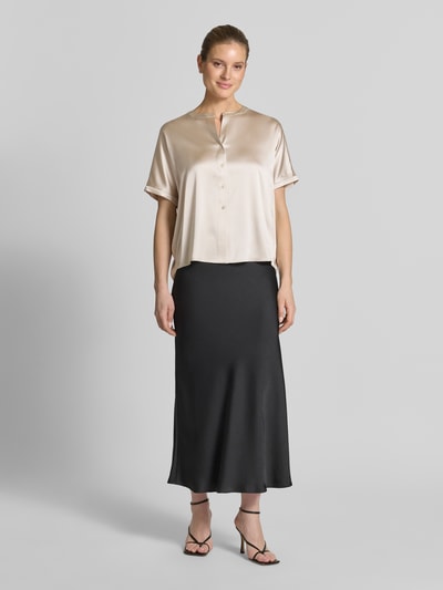 Kobiece model prezentuje Relaxed Fit Seidenbluse mit Rundhalsausschnitt od HERZENS, jasny beż, krótki rękaw, jedwabny elastyczny materiał, pełna lista guzików, długość tyłu w rozmiarze 36: 63 cm, długość rękawa: 18 cm, widok całej sylwetki z przodu