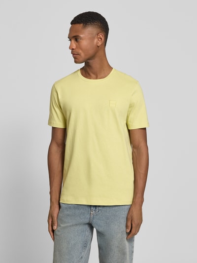 Männermodel trägt Regular Fit T-Shirt aus reiner Baumwolle Modell 'TALES' von BOSS Orange in Hellgelb, unifarben, Nahaufnahme Oberkörper.