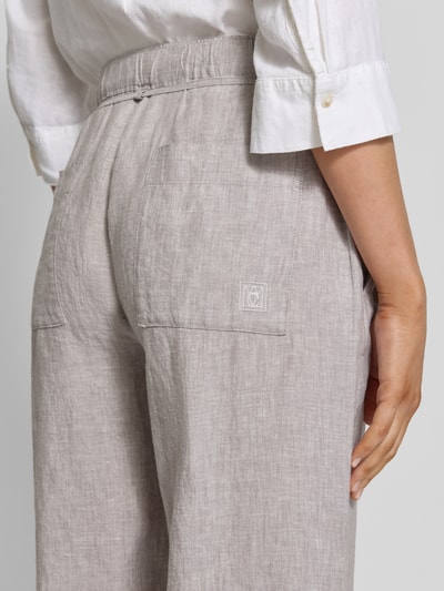 Frauenmodel trägt Leinenhose mit Bindegürtel Modell 'Chiara Belt' von MAC, hellbeige, reines Leinen, Nahaufnahme Rückansicht.