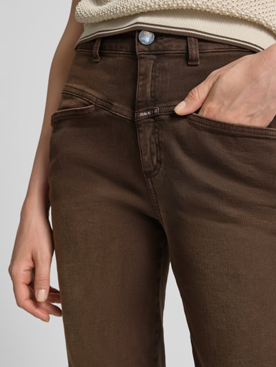 Kobieta nosi Relaxed Fit Jeans mit Label-Detail Model 'PEDAL PUSHER' od Closed, Mieszanka bawełny z dodatkiem streczu, wpuszczane kieszenie, detal z logo, szerokość w rozmiarze 27/32: 36 cm, długość wewnętrzna nogawki w rozmiarze 27/32: 70 cm, brązowe odcienie, gładka tekstura, zbliżenie na okolice pasa