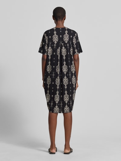 Frauenmodel trägt knielanges Kleid mit V-Ausschnitt Modell 'Floy' von FREE/QUENT im Material-Mix mit Stretch-Anteil, Ganzkörperansicht Rückansicht.