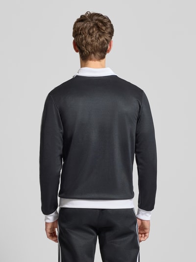 Männermodel trägt Regular Fit Trainingsjacke mit Stehkragen Modell 'Classic' von adidas Originals im Baumwoll-Mix, Rückenansicht.