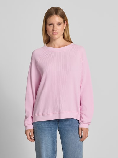 Vrouwenmodel draagt sweatshirt met structuurpatroon Model 'USCOW' van American Vintage in lichtroze, puur katoen, relaxed fit, ronde hals, ruglengte maat XS/S 64 cm, voorkant volledige lichaamsweergave.