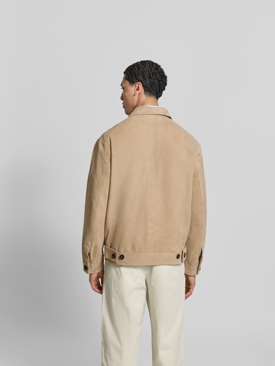 Männermodel trägt Regular Fit Jacke aus echtem Ziegenleder von ANNARR, beige Farbe, Umlegekragen, Eingrifftaschen, Zweiwege-Reißverschluss, Ganzkörperansicht Rückansicht.