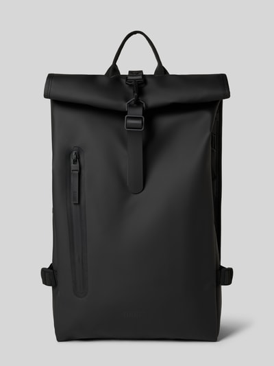 Produktfoto, Rolltop Rucksack mit Reißverschlusstasche von RAINS in mattem Schwarz, Karabinerhaken, Tragehenkel, verstellbare Träger, klare Linien, glatte Oberfläche