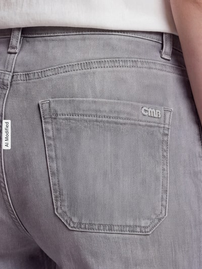 Männermodel trägt Regular Fit Schlaghose aus Baumwoll-Mix Modell 'AMARA' von CAMBIO, Damen spodnie rozszerzane, jasnoszary kolor, widoczna tylna kieszeń, tekstura gładka, detal tylnej kieszeni, Ganzkörperansicht Rückansicht, KI-modifiziertes Bild.