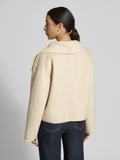 Frauenmodel trägt Jacke aus Woll-Mix Modell 'Naria' von Someday in Creme, Relaxed-Fit mit Viskose-Anteil, Druckknopfverschluss, Rückenlänge 55 cm, Schulterbreite 48 cm, Brustweite 50 cm, Ärmellänge 55 cm, Ganzkörperansicht Rückansicht.