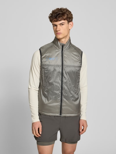 Männermodel trägt graue Herren Weste mit Logo und Stehkragen Modell 'HALO SABER' von HALO, Regular-Fit, Reißverschluss, Ganzkörperansicht von vorne. Rückenlänge 68 cm, Schulterbreite 40 cm, Brustweite 37 cm.