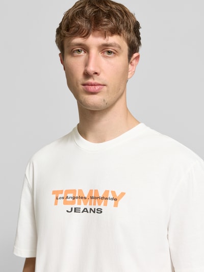 Männermodel trägt Regular Fit T-Shirt aus reiner Baumwolle von Tommy Jeans mit Optik: Unifarben, Label-Schriftzug, Nahaufnahme Oberkörper.