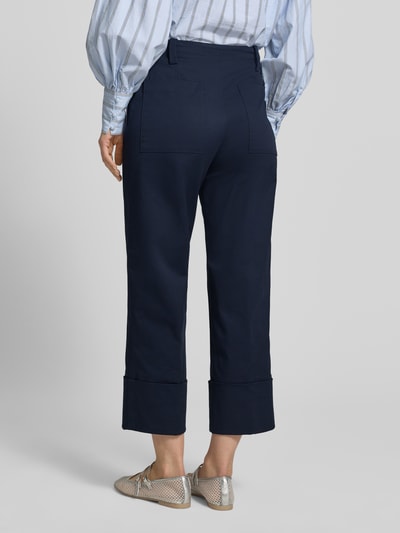 Frauenmodel trägt dunkelblaue Hose mit fixiertem Aufschlag Modell 'PANTALONE' von Stefanel, Baumwoll-Mix mit Stretch-Anteil, Ganzkörperansicht Rückansicht.
