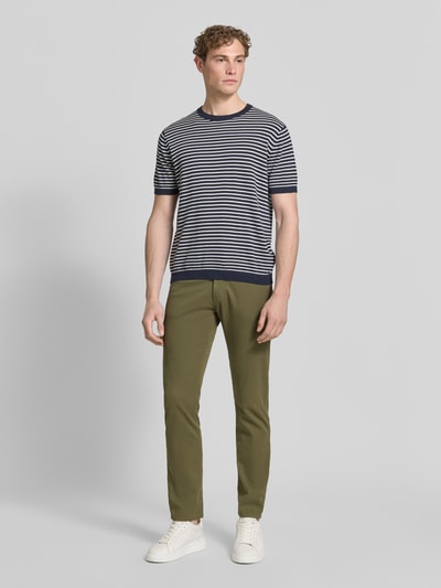 Männermodel trägt Tapered Fit Hose mit Eingrifftaschen Modell 'Lyon' von Pierre Cardin aus Baumwoll-Elasthan-Mix, Ganzkörperansicht von vorne.