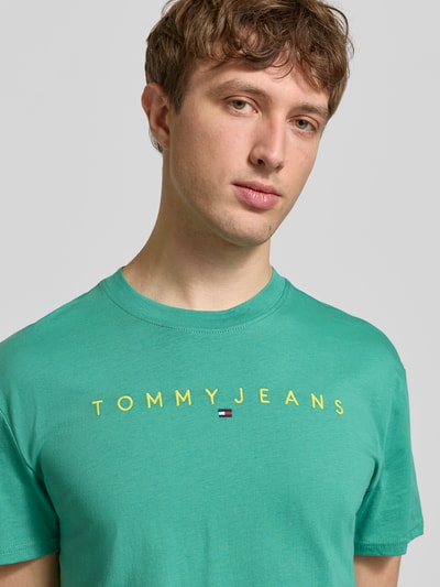 Männermodel trägt Regular Fit T-Shirt aus reiner Baumwolle von Tommy Jeans, Optik: Unifarben, Logo-Stitching, Rundhals, Kurzarm, Nahaufnahme Oberkörper