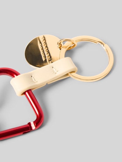 Productfoto, sleutelhanger met karabijnsluiting model 'HEART TO HEART' van Seidenfelt in goud en rood met labeldetail, dames sleutelhanger, sleutelring, context Seidenfelt