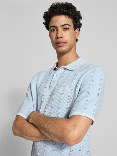 Męskimodel nosi koszulkę polo Regular Fit Poloshirt in Strick-Optik Modell 'Menton' od Jack & Jones, bawełna, krój regular fit, imitacja dzianiny, długość tyłu w rozmiarze M: 70 cm, jasnoniebieski kolor, tekstura ażurowa, z krótkim rękawem, półzbliżenie przód