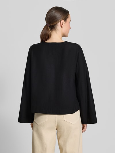 Frauenmodel trägt Blusenshirt aus Viskose-Mix mit Schnürung von Vila, schwarze Farbe, Regular-Fit, Modell 'PRISILLA', Ganzkörperansicht Rückansicht.