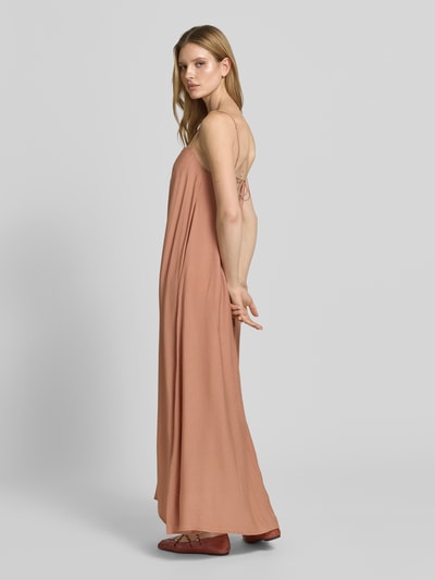 Frauenmodel trägt Maxikleid mit Spaghettiträgern und Karree-Ausschnitt von Style Icon Collection in Zimtbraun, Lockerer-Schnitt, glatte Textur, Rücken mit Schlüsselloch-Ausschnitt und Bindung, Brustweite bei Größe 36: 27 cm, Ganzkörperansicht Rückansicht.