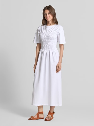 Frauenmodel trägt Midikleid mit Smok-Details von Jake*s Casual aus Reine Baumwolle, Taillierter Schnitt, Rundhalsausschnitt, Ganzkörperansicht von vorne.