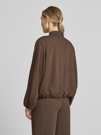 Frauenmodel trägt dunkelbraunen Blouson aus Lyocell-Mix mit Stehkragen von Drykorn, Relaxed-Fit, Rückenlänge 55 cm, Ganzkörperansicht Rückansicht.