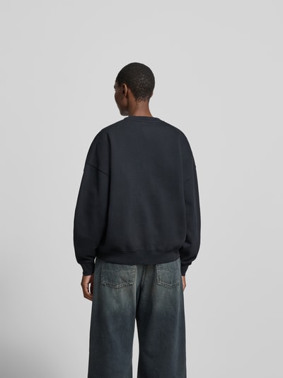 Frauenmodel trägt Regular Fit Sweatshirt mit Logo-Print von Anine Bing, Reine Baumwolle, Rundhalsausschnitt, Elastische Abschlüsse, Rückenlänge 63 cm, Ganzkörperansicht Rückansicht.