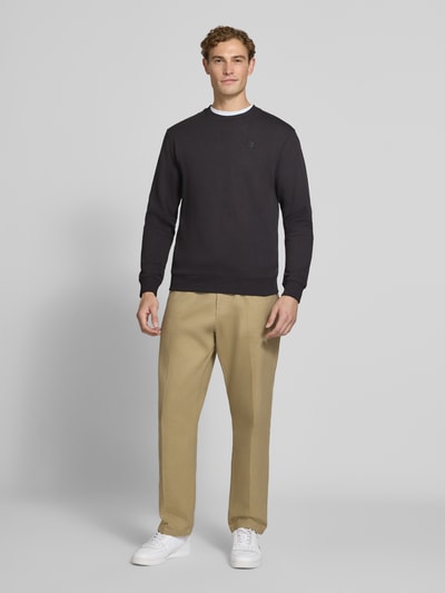 Männermodel trägt Regular Fit Sweatshirt aus reiner Baumwolle mit Label-Patch von Scotch & Soda, Beigehose, weiße Sneaker, Ganzkörperansicht von vorne. Kontext: Herren Sweatshirt, elastische Abschlüsse, Rückenlänge 70 cm, Ärmellänge 66 cm.