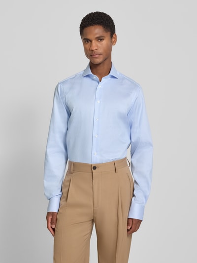 Männermodel trägt Extralanges Regular Fit Business-Hemd mit Haifischkragen von Christian Berg Men in Hellblau, Reine Baumwolle, Ganzkörperansicht von vorne. Rückenlänge 84 cm, Schulterbreite 47 cm, Ärmellänge 70 cm, Knopfleiste.