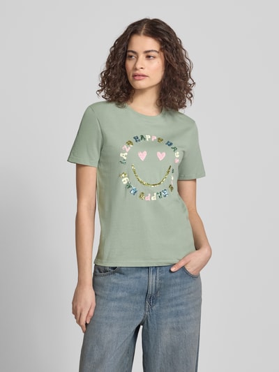 Modelka nosi Regular Fit T-Shirt aus reiner Baumwolle Modell 'KITA' od Only, kolor jednolity, motyw nadruku z cekinami, krótki rękaw, jersey, zielony; widok całej sylwetki z przodu.