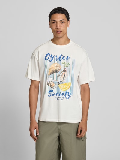 Männermodel trägt T-Shirt mit Motiv-Print von REVIEW in Weiß, Baumwoll-Mix mit Bio-Baumwoll-Anteil, Gerader-Schnitt, Rundhalsausschnitt, Ganzkörperansicht von vorne.