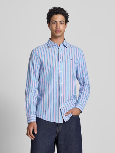 Männermodel trägt Regular Fit Freizeithemd aus Leinen-Baumwoll-Mix von Tommy Jeans, gestreift, mehrfarbig, Ganzkörperansicht von vorne.