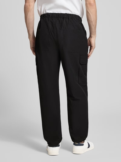 Männermodel trägt Regular Fit Hose mit Cargotaschen Modell 'LOGAN' von Antony Morato, schwarzer Baumwoll-Mix, Rückansicht Ganzkörperansicht.