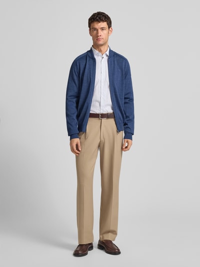 Männermodel trägt Strickjacke aus Schurwolle mit Reißverschluss von MAERZ Muenchen in Blau, Regular-Fit, Stehkragen, Ganzkörperansicht von vorne.