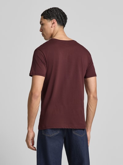 Mannenmodel draagt T-shirt met Label-Details model 'BASIC' van Alpha Industries in puur katoen, recht model, ronde hals, ruglengte maat M 67 cm, Ganzkörperansicht Rückansicht.