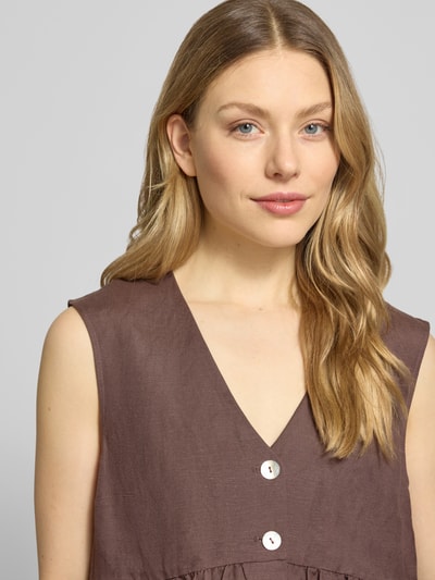 Vrouwenmodel draagt Top uit linnenmix met viscose-aandeel van Christian Berg Woman Selection, getailleerde pasvorm, V-hals, knoopsluiting, plooien, ruglengte maat 36: 61 cm, schouderbreedte maat 36: 40 cm, borstwijdte maat 36: 45 cm, close-up bovenlichaam.