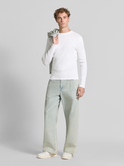 Männermodel trägt Slim Fit Longsleeve aus reiner Baumwolle Modell 'Enil' von DRYKORN, weiß, Strukturmuster, Ganzkörperansicht von vorne.