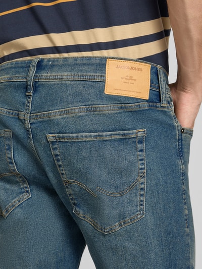 Männermodel trägt Straight Fit Jeans mit Lyocell-Anteil Modell 'GLENN' von JACK & JONES, Used-Look, Detailaufnahme Rückansicht, Baumwoll-Lyocell-Mix mit Viskose-Anteil, 5-Pocket-Design, sichtbares Lederlabel.