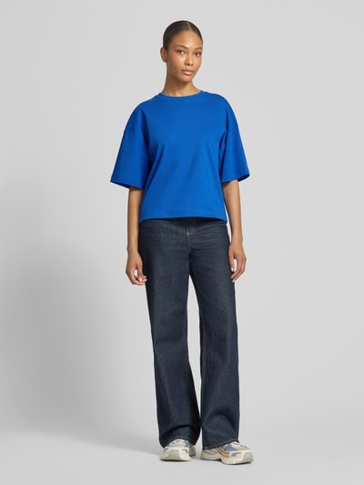 Frauenmodel trägt Oversized T-Shirt aus reiner Baumwolle von s.Oliver RED LABEL in Optik: Unifarben, Passform: Oversized, Logo-Applikation, Rundhals, Ärmelform: Kurzarm, Materialverarbeitung: Jersey, Ganzkörperansicht von vorne.