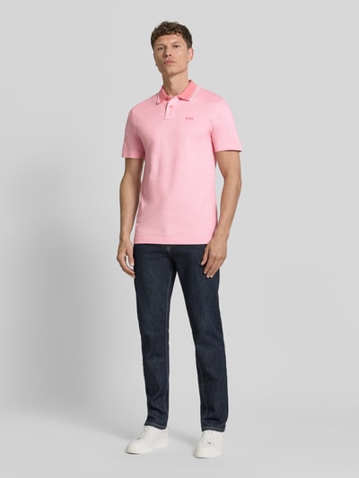 Männermodel trägt Relaxed Fit Poloshirt aus reiner Baumwolle Modell 'PEOXFORDNEW' von BOSS, mehrfarbig, vorne, Ganzkörperansicht.