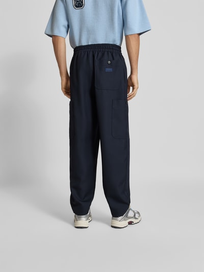 Männermodel trägt Regular Fit Leinenhose mit Cargotasche von Kenzo in Dunkelblau, elastischer Bund mit Tunnelzug, Gesäßtasche, Ganzkörperansicht Rückansicht.