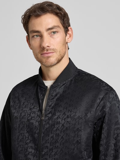 Männermodel trägt Blouson mit Zweiwege-Reißverschluss von ARMANI EXCHANGE in zwart met geribde boorden, recht model, nahaufnahme oberkörper.