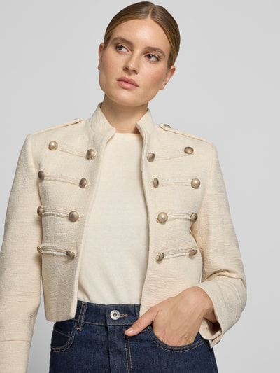 Frauenmodel trägt Blazer mit Zierknöpfen Modell 'CHARLIE' von MANGO in Creme, Baumwoll-Mix, Stehkragen, gerade Form, Nahaufnahme Oberkörper.