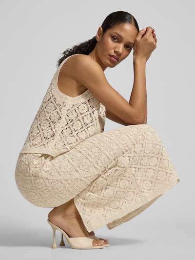 Kobieta modelka nosi Strickrock mit Gehschlitz od JAKE*S STUDIO WOMAN, A-linia, midispódnica, rozcięcie, elastyczny pas, kremowy kolor, tekstura ażurowa, szerokość w rozmiarze 36: 36 cm, długość całkowita 87 cm, zdjęcie całej sylwetki z boku.